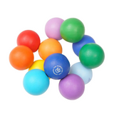 A set of colorful foam stress balls arranged in a circle on a plain white background. The balls are in multiple bright colors including blue, green, orange, red, yellow, purple, and light blue, with one blue ball featuring a white printed logo.